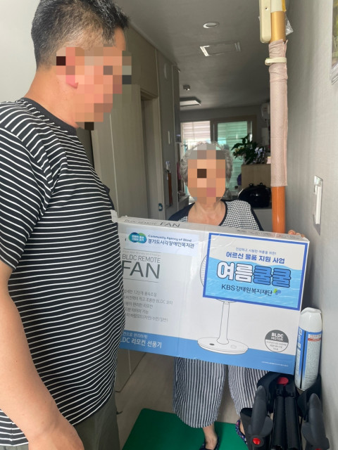 선풍기를 전달받는 참여자의 모습