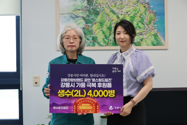 ‘로스팅 드림즈’ 최미경 총괄프로듀서(오른쪽)는 강릉시청을 방문해 심상복 강릉시 문화관광해야국장에게 강릉가뭄극복 동참을 위한 생수(2L) 4000병을 전달했다