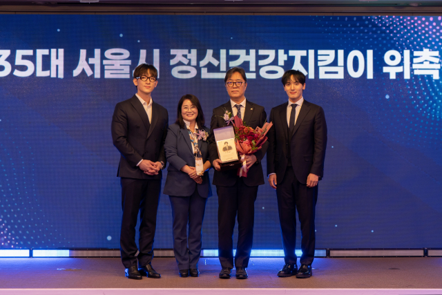 제35대 서울시정신건강지킴이로 위촉된 연세라이프정신건강의학과 이명수 원장(오른쪽 두번째)에게 제34대 서울시정신건강지킴이 포르테나 오스틴킴, 서영택 씨가 위촉패, 위촉배지, 꽃다발을 전했다