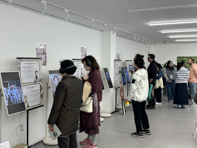 시민들이 전시 작품을 관람하며 독립운동가의 AI 복원 영상을 살펴보고 있다