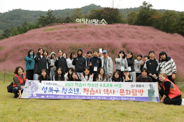 청소년들이 아름다운 핑크뮬리가 펼쳐진 아양사랑숲에서 함께 사진을 촬영하고 있다
