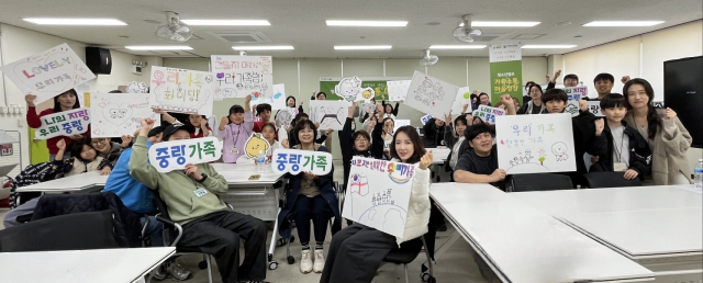 참여 가족이 가족 사랑과 응원 메시지를 담은 가족 명패를 들고 포즈를 취하고 있다