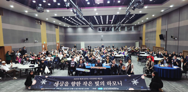 참석자들이 ‘세상을 향한 작은 빛의 하모니’라고 적혀 있는 현수막을 들고 단체 기념 촬영을 하고 있다