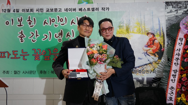 월간 시사문단 손근호 발행인에게 출간패를 수여받는 이보희 시인