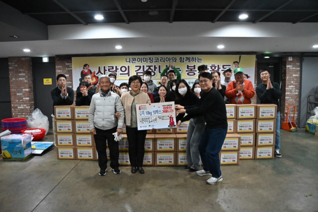 니콘이미징코리아 임직원들이 김장 봉사 활동 후 단체사진을 촬영하고 있다