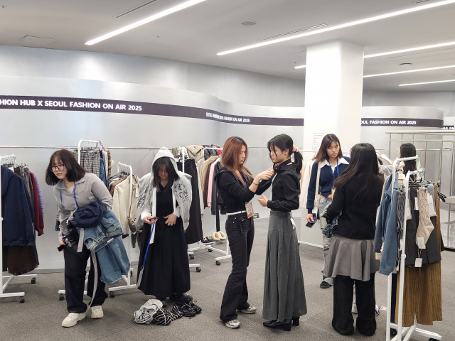 패션디자인서포터즈 대학생 멘토들이 동대문디자인플라자(DDP) 쇼룸 샘플스토어에서 청소년 참가자들의 조별 콘셉트에 맞춰 의상 선택과 스타일링을 도와주며 룩북 촬영 체험을 하고 있다