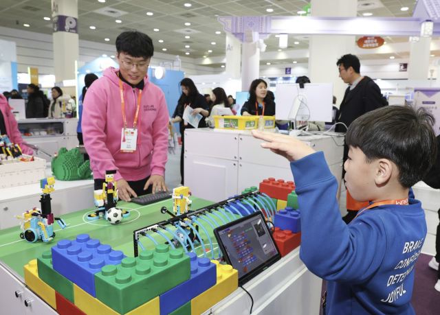 AI이거다 솔루션을 활용한 축구로봇을 관객이 체험하고 있다