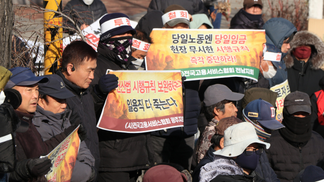 한 건설일용노동자가 ‘일용직 다 죽는다’는 피켓을 들고 현실을 외면한 시행규칙 개정 중단을 호소하고 있다