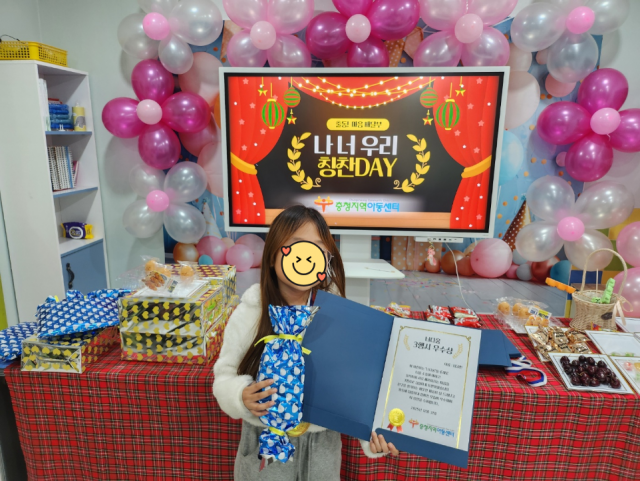 ‘나·너·우리 칭찬Day’에 참여한 한 아동이 기념 촬영을 하고 있다