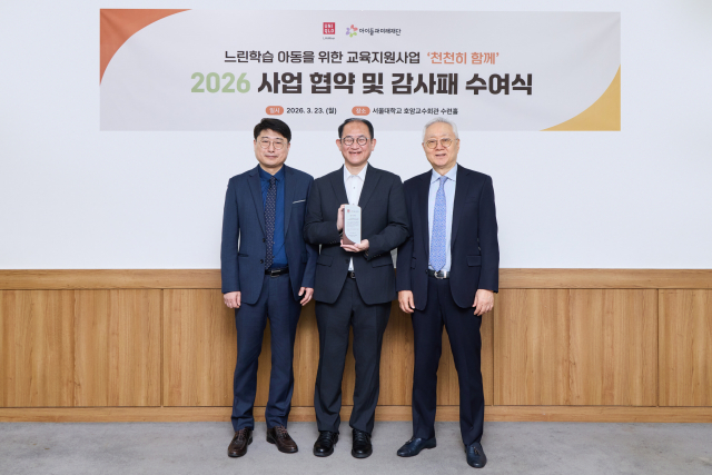 ‘천천히 함께’ 4차년도 사업 출범 협약식에서 공무원연금공단 서울지부 이상영 부장(왼쪽)이 전달한 감사패를 들고 사진 촬영을 하고 있는 패스트리테일링 닛타 유키히로 서스테이너빌리티 담당 그룹 집행 임원(가운데)과 아이들과미래재단 이훈규 이사장