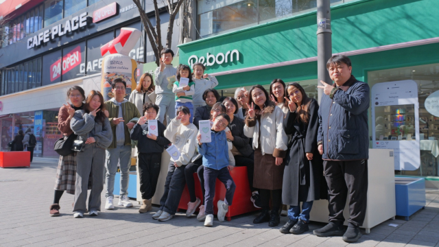 행사에 참여한 부모와 아이들이 신촌 리본 매장 앞에서 기념사진을 촬영하고 있다