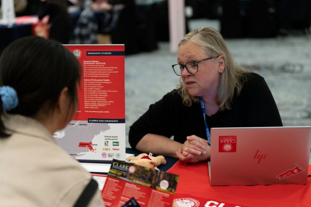 QS 박람회에서 행사 참가자가 학교 담당자와 대화를 나누고 있다