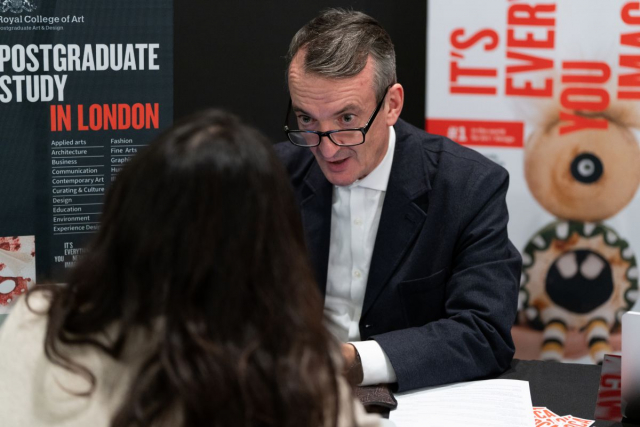 QS 박람회에서 행사 참가자가 학교 담당자와 대화를 나누고 있다