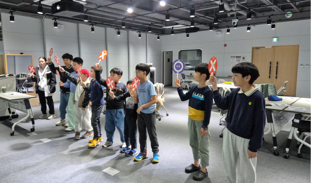 이틀간 학습한 AI 윤리 내용을 직접 적용해보는 골든벨 활동에서 청소년들이 저마다의 답을 들고 적극적으로 참여하고 있다