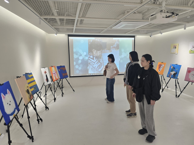 청담플래뮤 미술학원과 KOC가 유기견 보호 인식 확산을 위해 어린이 그림 전시회를 개최한다. 사진은 전시장에서 작품을 감상하는 관람객들의 모습