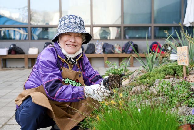 수정구치매안심센터 ‘추억정원 보식활동’에 참여한 어르신이 꽃을 심으며 정원 가꾸기에 참여하고 있다(사진=숲생태지도자협회)