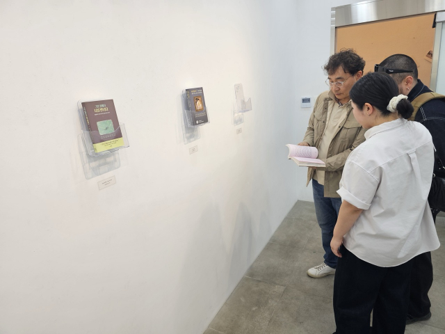 관람객들이 ‘책이 된 미술관’ 전시회를 둘러보고 있다