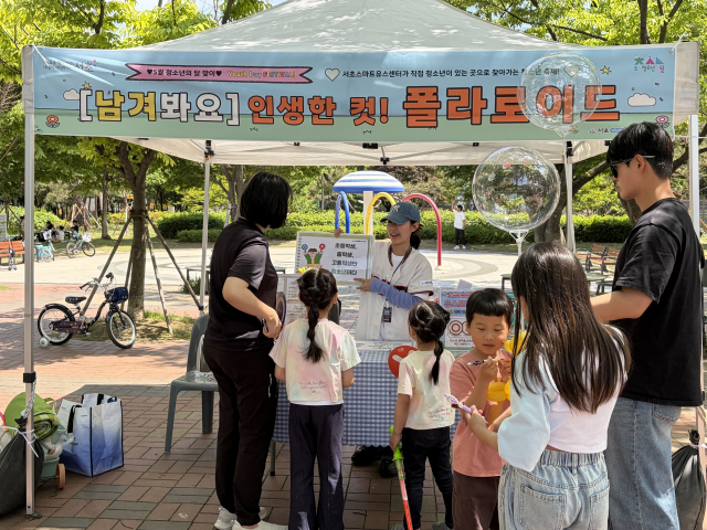 ‘찾아가는 청소년 축제’ 행사장을 찾은 한 가족이 포토존 및 폴라로이드 꾸미기 체험 부스에 참여하고 있다