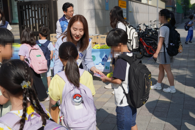 서울당서초등학교 어린이들이 캠페인에 참여해 등굣길 안전 수칙이 담긴 패널을 살펴보며 교통안전 실천을 다짐하고 있다