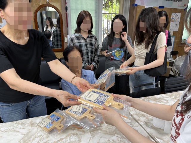 시립망우여자단기청소년쉼터 입소 청소년이 햇님경로당 어르신에게 직접 제작한 냄비받침을 전달하고 있다