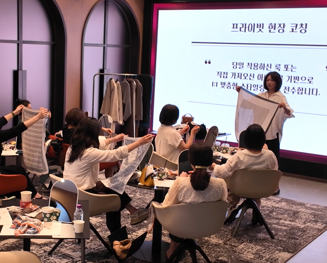 신한금융 VVIP 고객들이 배선영의 시연에 따라 직접 스카프 스타일링을 실습하고 있다. 이번 클래스는 참석자가 직접 따라 해보고 현장에서 코칭받는 참여형 방식으로 진행됐다