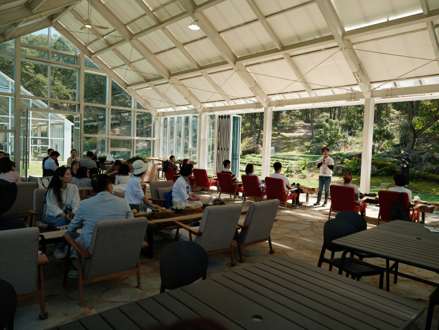 DMZ숲 유리온실에서 열린 Re:DMZ 팸투어. 숲을 향해 열린 온실 안에서 참가자들이 DMZ숲의 복원 이야기를 듣고 있다