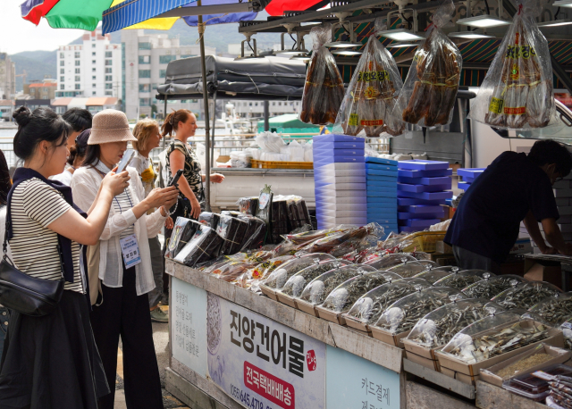 ‘어(魚)메이징 크루’ 참가자들이 통영중앙시장 건어물 거리에서 크기와 용도에 따라 판매되는 다양한 멸치를 살펴보고 있다