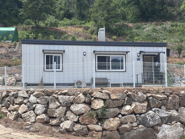 축대 위에 자리한 임시주택 둘레에 낙상을 막기 위한 펜스를 설치한 모습