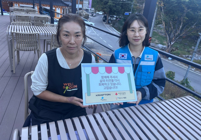 산불 피해로 영업이 어려웠던 식당 소상공인이 더프라미스와 함께 지원받은 야외 테이블 세트에 앉아 있다