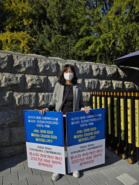 국회 정문 앞에서 지역아동센터총연대 관계자가 예산안 국회 증액 반영 촉구 피켓을 들고 1인 시위를 벌이고 있다