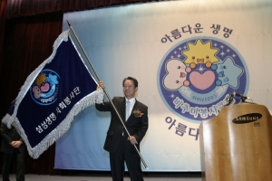 배정충 사장이 봉사단 창립 10주년을 맞아 제2기 비추미 봉사클럽을 상징하는 봉사단 깃발을