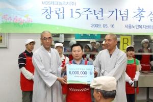 MDS테크놀로지 이상헌 사장(가운데)이 서울노인복지센터측에 후원금 600만원을 전달하고 있