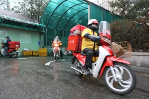 비가 내리는 가운데 서울광진우체국 집배원들이 선물소포 배달을 위해 우체국을 나서고 있다.