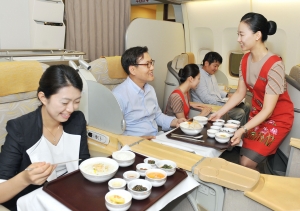 아시아나항공 승무원이 기내에서 여름 보양식인 황기 삼계죽과 삼계찜을 서비스 하고 있다.