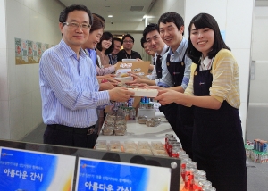 CJ프레시웨이 박승환 대표(사진 좌)와 직원들이 신입사원들로부터 구매한 간식을 건네 받고 