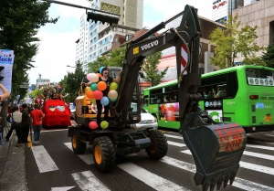 볼보건설기계 굴삭기가 2012 한국실험예술제의 개막을 할리는 행사에서 행진하고 있다.