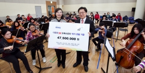 한국암웨이가 다문화 M오케스트라의 연습실을 찾아 악기 기금을 전달하고, 기념 촬영을 하고 