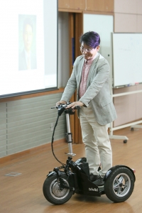자신이 개발한 전기자전거를 타고 강의장으로 들어서는 임진욱 대표의 모습이다.