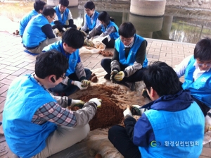 환경실천연합회 자원봉사자들이 하천정화를 위해 EM흙공을 만들고 있다.