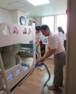 이든아이빌 아이들의 생활 공간을 청소하고 있는 유지일 사장(맨 앞쪽)과 임직원들.