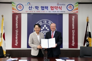 김형태 한남대학교 총장과 이득춘 이글루시큐리티 대표가(사진 왼쪽) 협약서를 들고 있다.