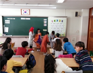 다문화 인권지킴이 교육을 받고 있는 초등학교 학생들이 싱가폴 의상을 입어보고 있다