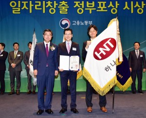 김진환 하나투어 관리본부장(가운데)이 일자리창출 유공 대통령표창을 받은 후 이기권 고용노동