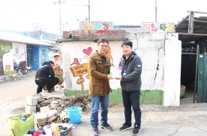 희망이음 대외협력팀 이봉재 과장이 문산종합사회복지관 김요섭 팀장에게 벽화 7호 현판을 전달