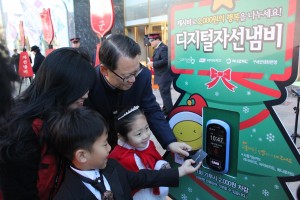 어린이가 디지털자선냄비에 교통카드를 태그하여 기부하고 있다