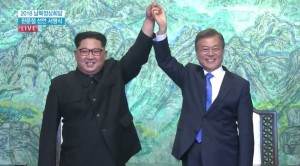 문재인 대통령과 김정은 위원장이 판문점 선언문에 서명한 뒤 손을 들어 보이고 있다