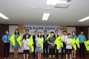 도로교통공단 서울지부가 서울 청운초등학교에서 노랑깃발 휘날리며, 안전하게 건너요라는 내용으