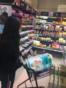 어르신이 요청한 생필품 목록을 보며 장보기를 진행하는 청소년 봉사자