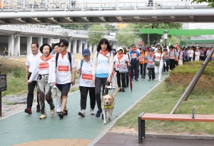300여명의 회원과 시각장애인들이 도림천변 산책로를 걷고 있다