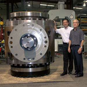 맷 모가스(왼쪽)와 루이스 모가스(오른쪽)가 거대한 모가스 밸브 옆에서 포즈를 취하고 있다
